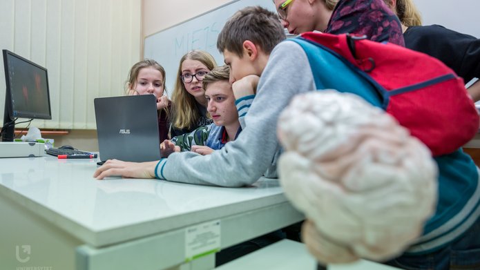 Dzieci w klasie szkolnej oglądają coś na komputerze